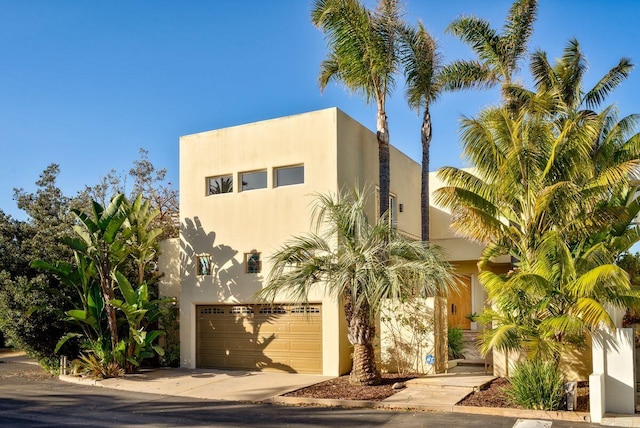 view of front of home with a garage, stucco siding, and concrete driveway