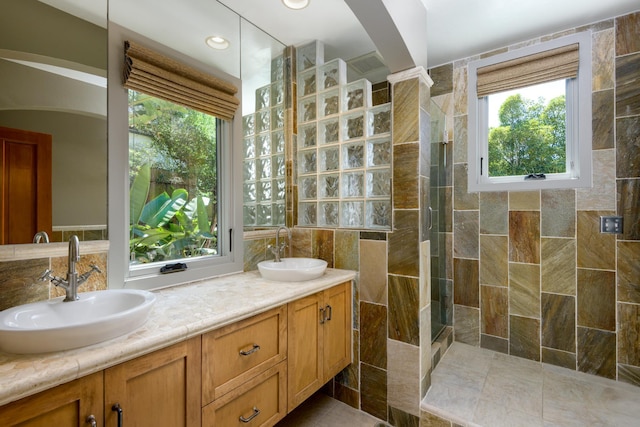 full bathroom with a sink, a wealth of natural light, and a tile shower