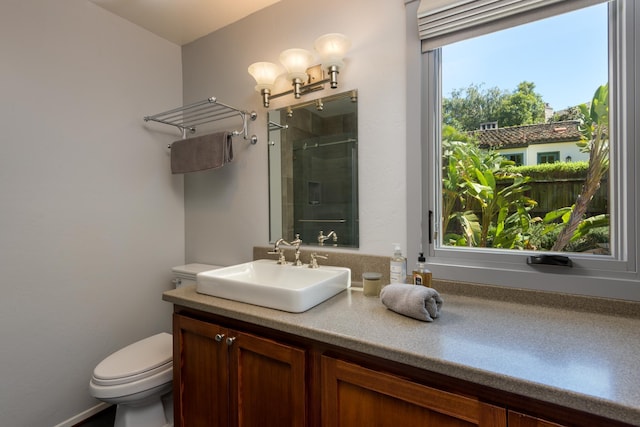 bathroom with vanity, toilet, and a shower stall