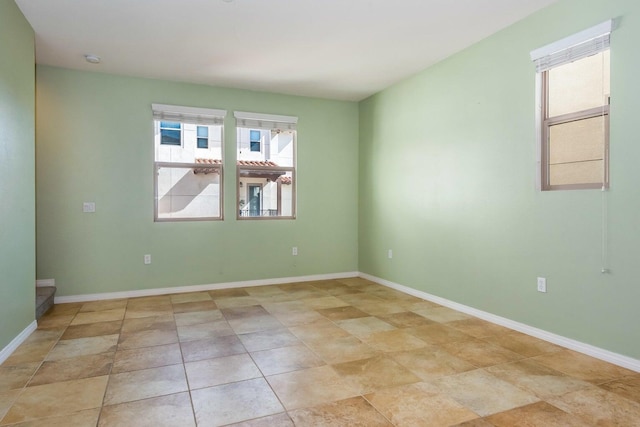 empty room featuring baseboards and a wealth of natural light