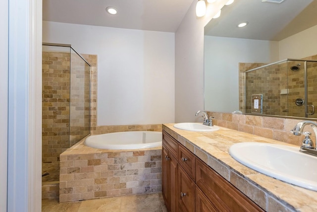 bathroom featuring double vanity, a sink, a garden tub, and a shower stall