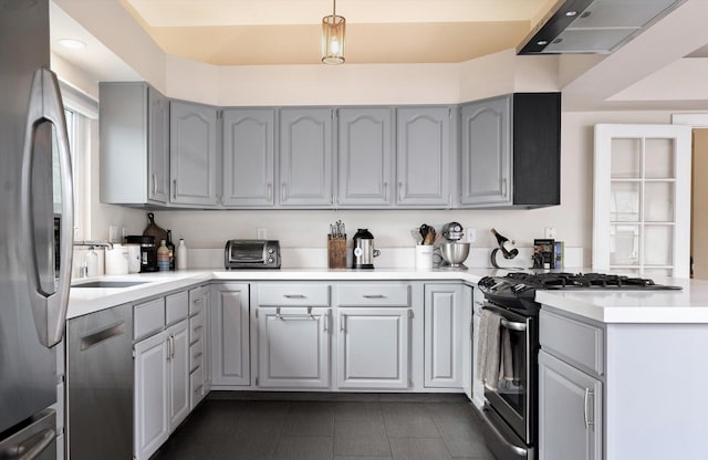kitchen with light countertops, appliances with stainless steel finishes, gray cabinetry, and dark tile patterned flooring