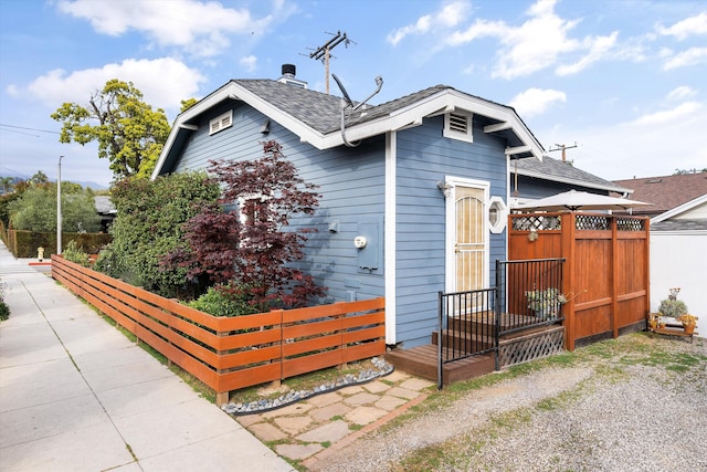 bungalow-style house with fence and roof with shingles