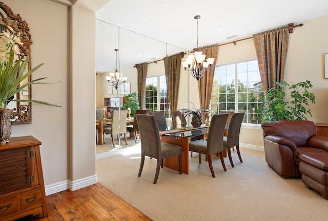 dining room featuring an inviting chandelier, baseboards, recessed lighting, and wood finished floors