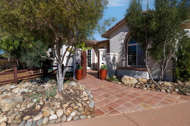mediterranean / spanish house featuring stucco siding and a tiled roof