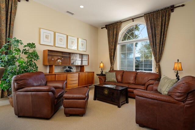 living area featuring visible vents, recessed lighting, and light carpet