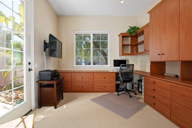 office area with light colored carpet and built in desk