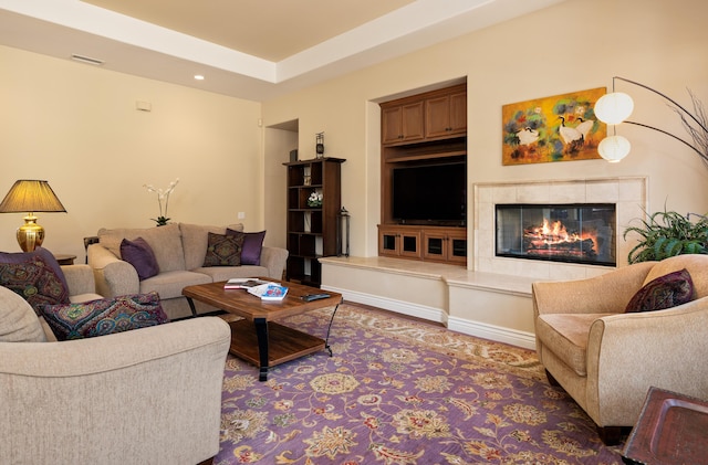 living room featuring recessed lighting, a tile fireplace, and visible vents