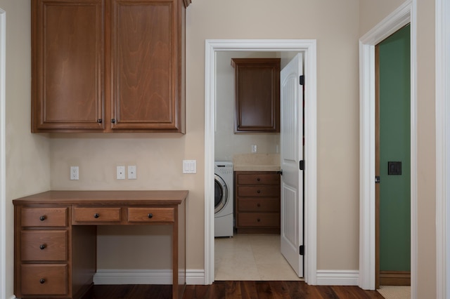 clothes washing area featuring washer / clothes dryer, laundry area, baseboards, and wood finished floors