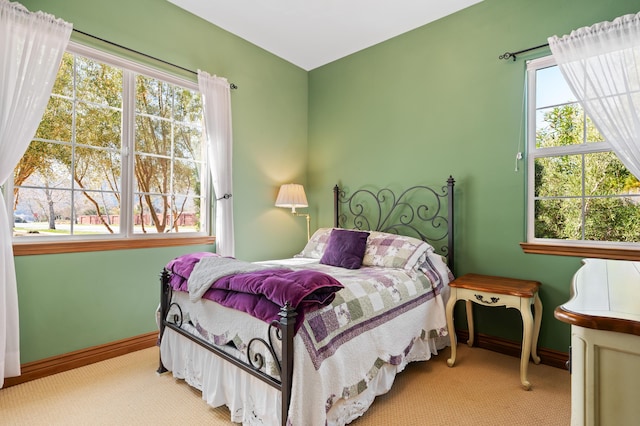 bedroom featuring carpet floors, baseboards, and multiple windows