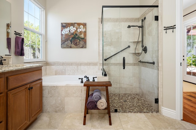 bathroom featuring vanity, a shower stall, and a garden tub