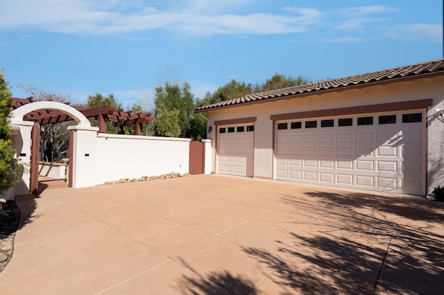 detached garage featuring fence and a gate