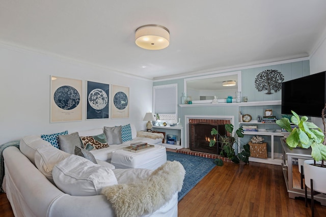 living area featuring ornamental molding, wood finished floors, and a fireplace