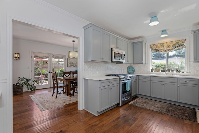 kitchen with backsplash, stainless steel appliances, dark wood finished floors, and gray cabinets