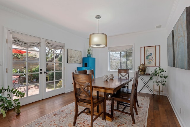 dining room with baseboards, ornamental molding, wood-type flooring, and french doors