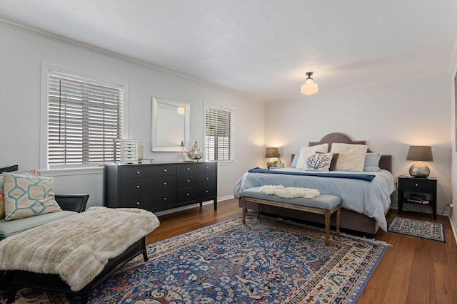 bedroom with crown molding, dark wood finished floors, and multiple windows