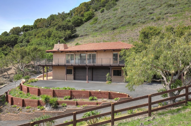 35 Hollister Ranch Rd, Goleta, CA 93117 - back of property with stucco siding, a vegetable garden, a tiled roof, a view of trees, and a patio area