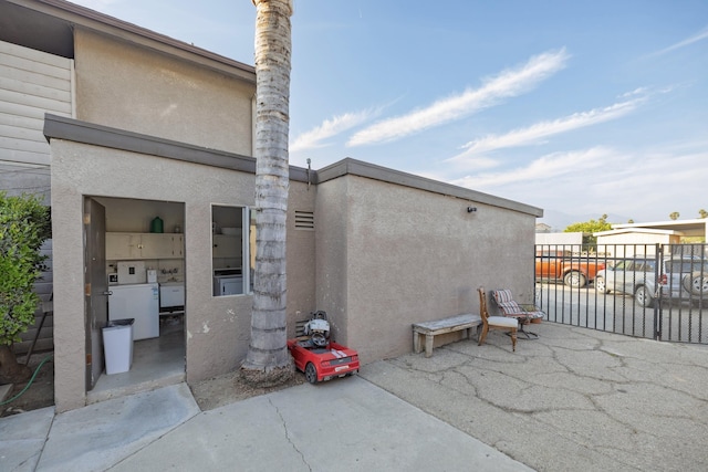 view of patio featuring a gate, washing machine and dryer, and fence