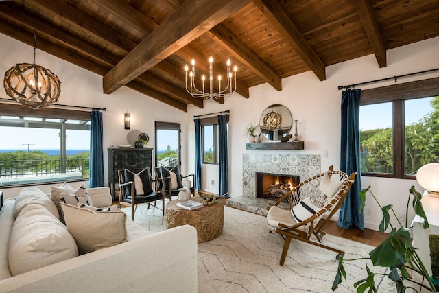 living area with lofted ceiling with beams, a notable chandelier, a fireplace, and wooden ceiling