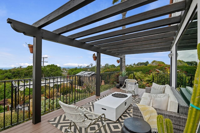 wooden terrace with an outdoor living space with a fire pit and a pergola