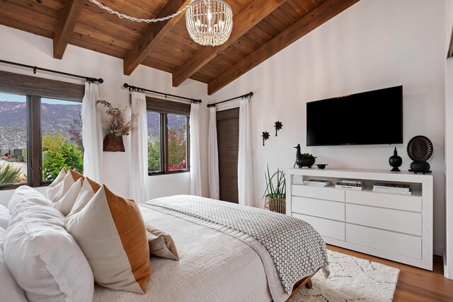 bedroom with wooden ceiling, a chandelier, multiple windows, and wood finished floors