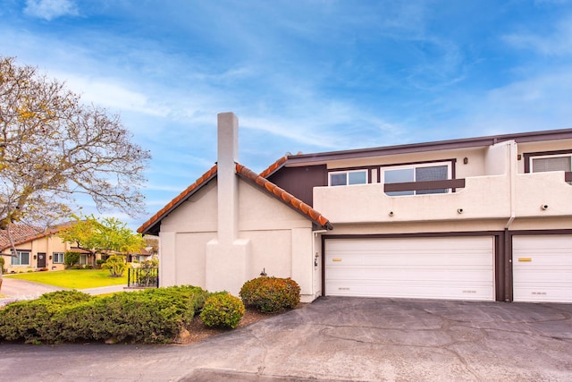 view of front of home with a garage, stucco siding, and driveway