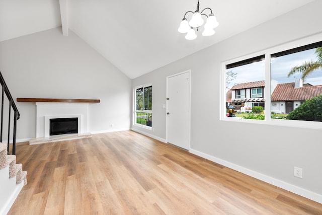 unfurnished living room with stairway, high vaulted ceiling, beamed ceiling, a chandelier, and a glass covered fireplace