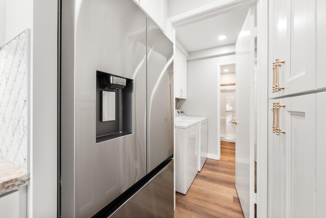 laundry area with baseboards, recessed lighting, light wood-type flooring, separate washer and dryer, and cabinet space