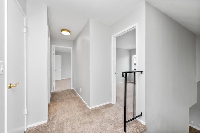 hallway featuring baseboards and carpet flooring