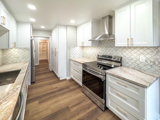 kitchen with wall chimney range hood, stainless steel appliances, light stone countertops, and dark wood-style flooring