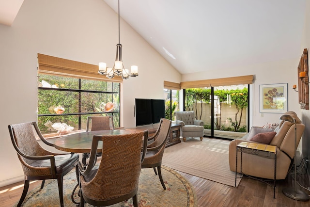dining room featuring an inviting chandelier, high vaulted ceiling, and hardwood / wood-style floors