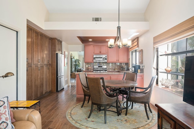 dining space with a notable chandelier, visible vents, and dark wood-style floors