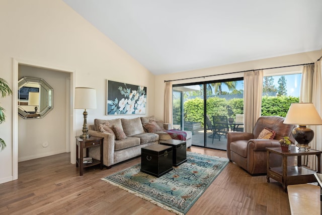 living room with baseboards, wood finished floors, and high vaulted ceiling