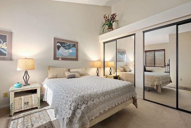 carpeted bedroom featuring baseboards and multiple closets