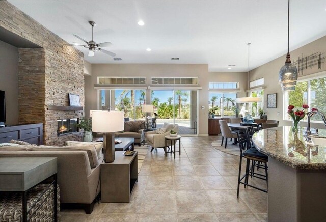 living room featuring recessed lighting, a ceiling fan, a wealth of natural light, and a fireplace