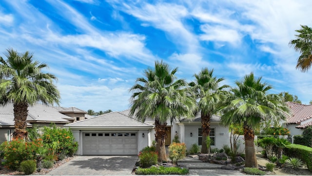 80220 Vía Tesoro, Tesoro, CA 92253 - view of front of home with an attached garage, driveway, a tile roof, and stucco siding