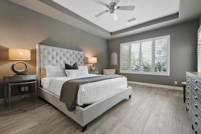 80220 Vía Tesoro, Tesoro, CA 92253 - bedroom with visible vents, baseboards, a raised ceiling, a ceiling fan, and light wood-style flooring