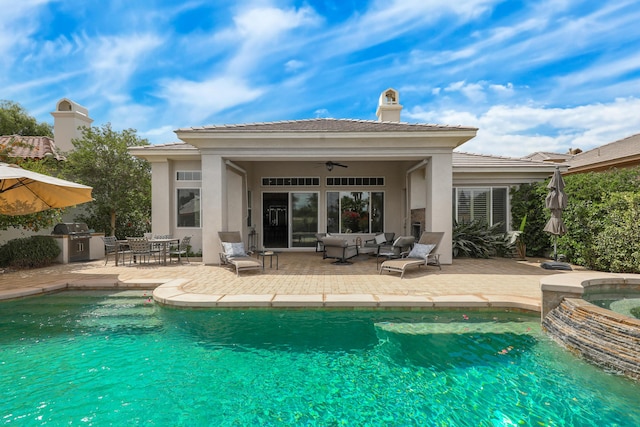 80220 Vía Tesoro, Tesoro, CA 92253 - back of house featuring exterior kitchen, a pool with connected hot tub, a patio area, an outdoor hangout area, and stucco siding