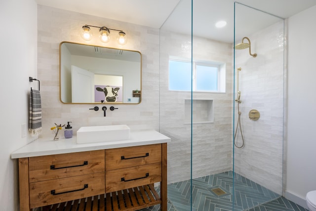 full bathroom featuring vanity, backsplash, a tile shower, and toilet