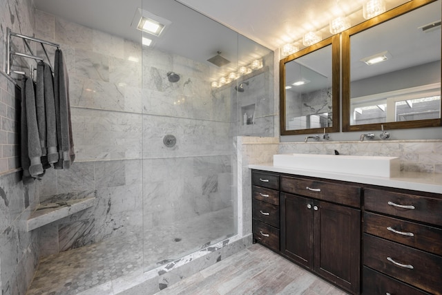 bathroom featuring vanity, walk in shower, wood finished floors, and visible vents