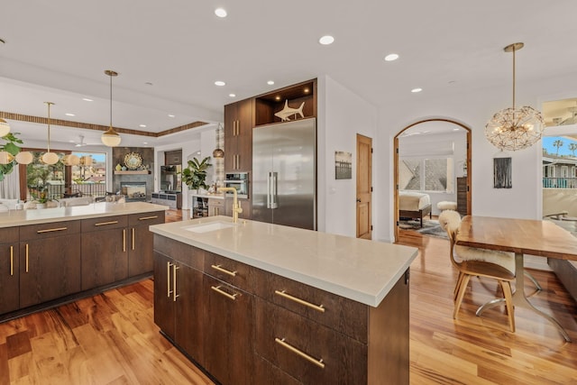 1158 Shelburn Ln, Ventura, CA 93001 - kitchen with dark brown cabinets, a sink, light wood-style floors, light countertops, and stainless steel appliances