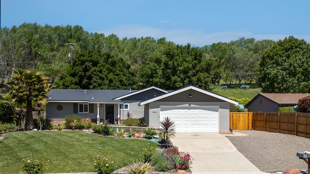 single story home featuring fence, an attached garage, a front yard, a forest view, and driveway