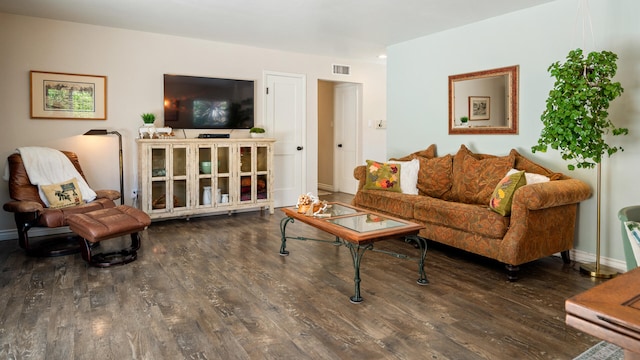 living area featuring baseboards, wood finished floors, and visible vents