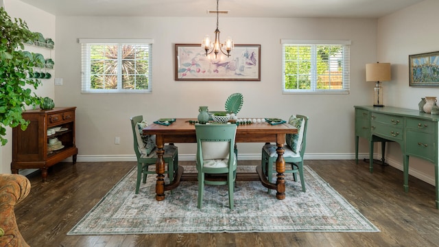 dining space featuring an inviting chandelier, baseboards, wood finished floors, and visible vents