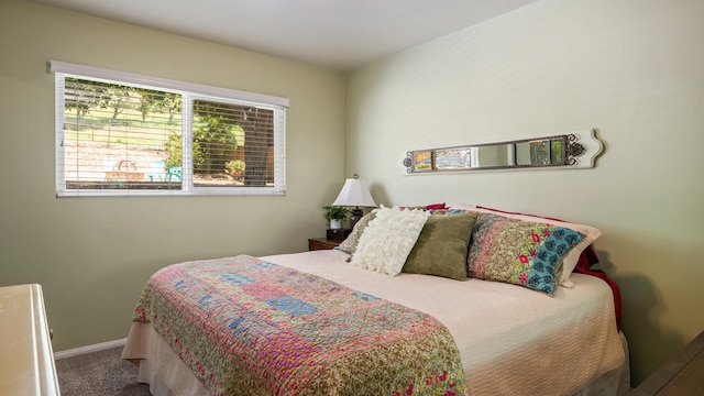 bedroom with baseboards and carpet