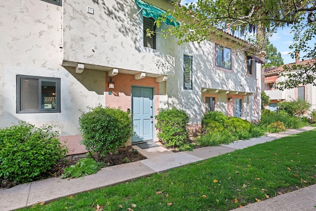 view of front facade with stucco siding and a front lawn