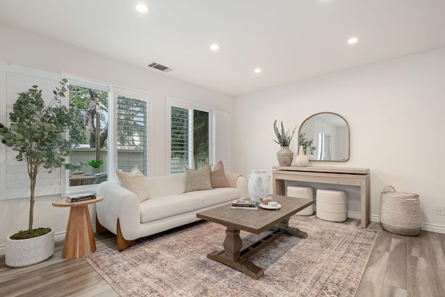 living room featuring wood finished floors, recessed lighting, and baseboards