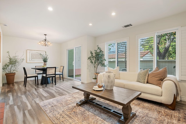 living room featuring light wood-style floors, a chandelier, recessed lighting, and baseboards