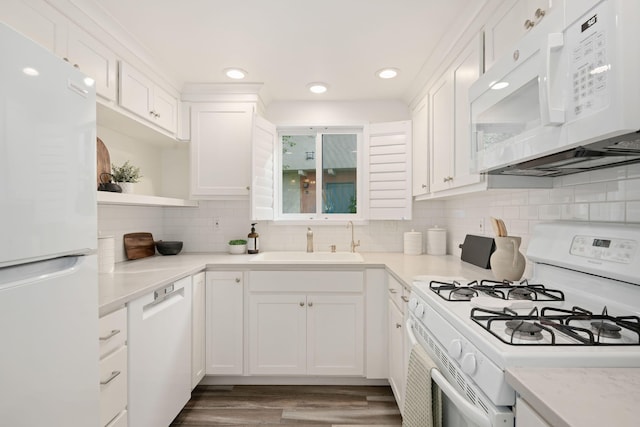 kitchen with white appliances, a sink, open shelves, white cabinetry, and wood finished floors