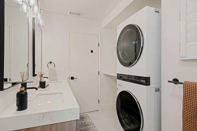 washroom featuring stacked washer / drying machine and light tile patterned floors